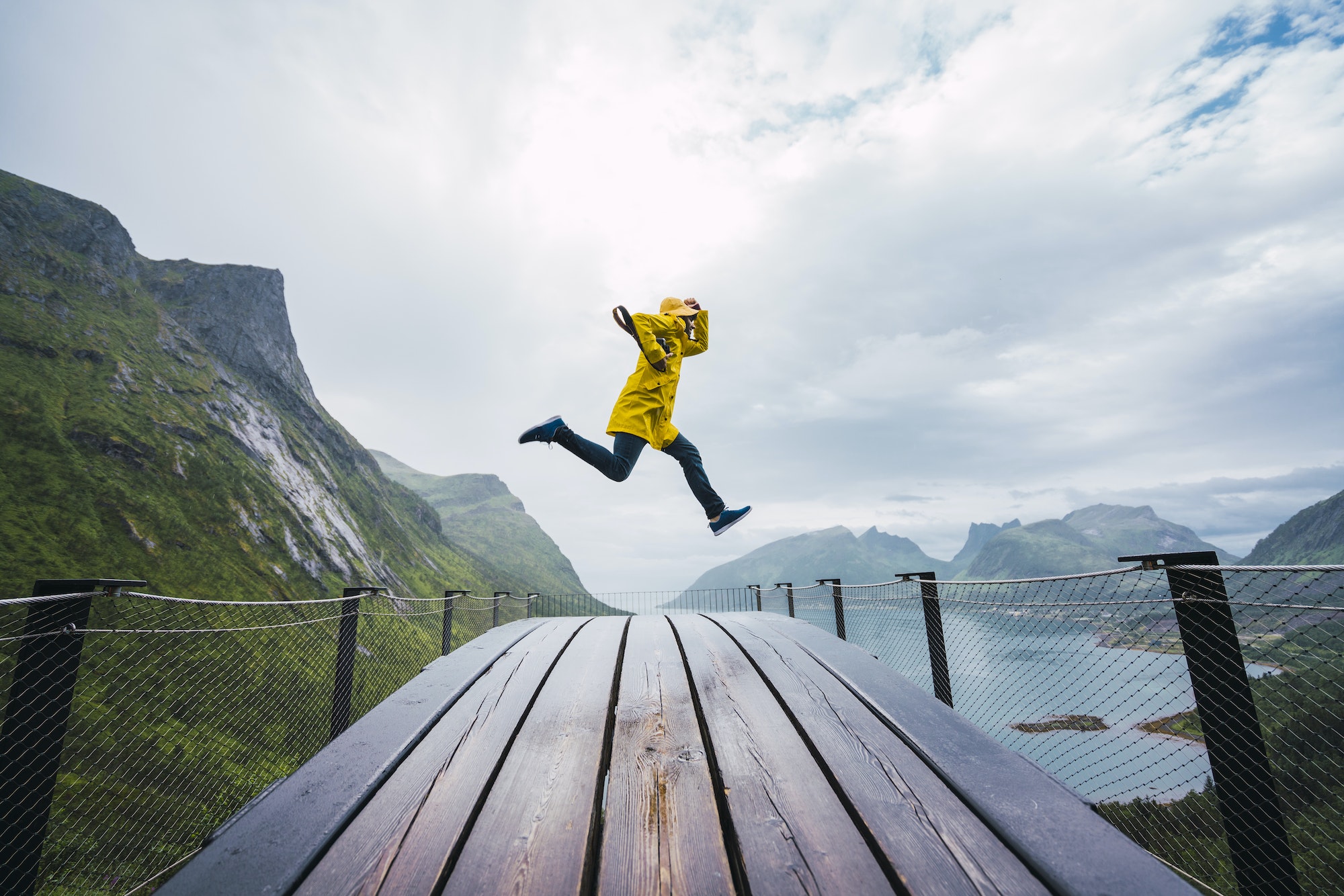 Norway, Senja island, man jumping on an observation deck at the coast