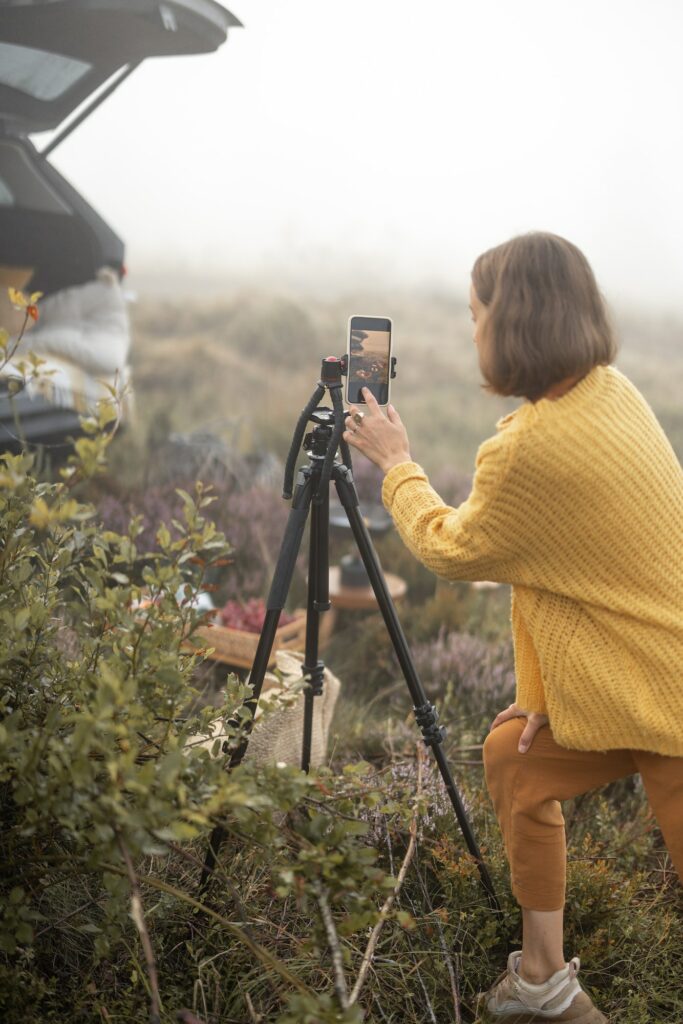 Woman traveler shooting on phone her picnic while travel